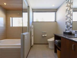 Experience modern luxury in this stunning bathroom featuring a deep soaking tub and a sleek vanity with ample storage.