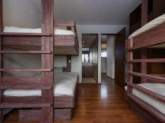 This spacious room features multiple wooden bunk beds, perfect for accommodating families or groups.