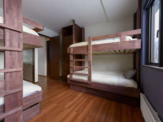 This spacious bedroom features multiple wooden bunk beds, perfect for accommodating families or groups.