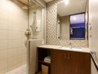 Experience modern comfort in this beautifully appointed bathroom, featuring a spacious glass-enclosed shower with a rainfall showerhead.