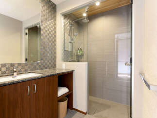 Experience modern luxury in this stunning bathroom featuring a sleek vanity with a granite countertop and rich wood cabinetry.