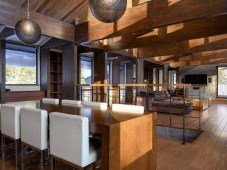 Experience luxurious living in this stunning open-concept dining and living area, featuring a grand wooden dining table with plush white chairs.