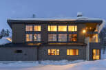 Experience luxury living in this modern mountain home, nestled amidst a serene winter landscape.
