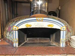 Experience authentic Italian cooking with this beautifully tiled wood-fired pizza oven, perfect for any restaurant or home chef.
