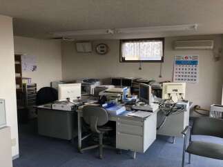 This office space features multiple workstations equipped with computers, printers, and ample storage solutions, perfect for a productive work environment.