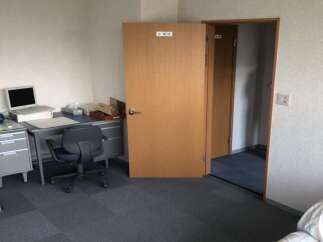 This office space features a functional desk setup with a laptop, filing cabinets, and a comfortable office chair, perfect for productivity.