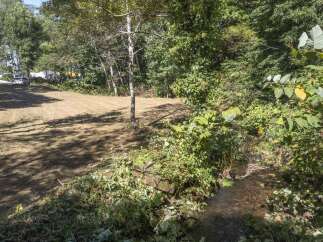 Discover this prime real estate opportunity featuring a cleared lot ready for development, adjacent to a tranquil stream.