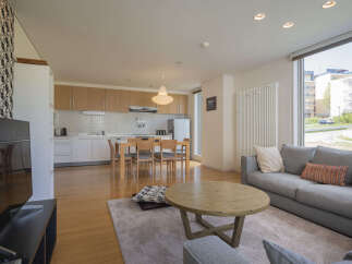 Experience modern living in this spacious open-plan apartment, featuring a sleek kitchen with ample cabinetry and a bright dining area perfect for family meals.