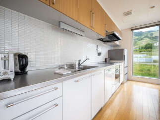 Experience modern living in this sleek kitchen featuring stainless steel countertops and white cabinetry.