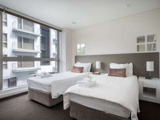 Experience modern comfort in this stylish hotel room featuring two twin beds, perfect for solo travelers or friends.