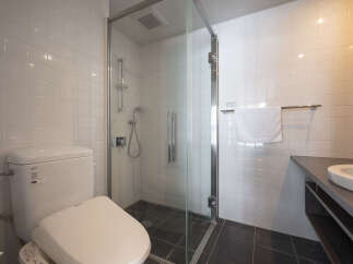 Experience modern comfort in this well-appointed bathroom, featuring a sleek glass-enclosed shower and a pristine white toilet.