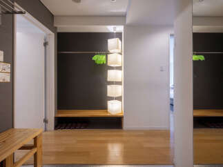 Welcome to this inviting entryway, featuring a convenient wooden bench for seating and shoe storage.