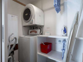 This laundry area features a stacked washer and dryer, perfect for maximizing space in your home.