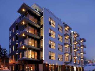Experience modern living in this stunning multi-story apartment building, featuring sleek architecture and numerous balconies perfect for enjoying the crisp winter air.