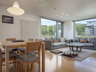 Experience modern living in this spacious apartment featuring a combined dining and living area with large windows offering scenic views.
