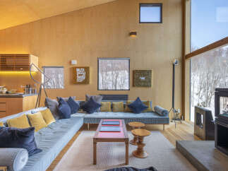 Experience modern living in this stunning home featuring a spacious sectional sofa and a striking wood-paneled interior.