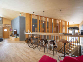 Experience modern living in this stylish space featuring a sleek bar area with unique cowhide-covered stools, perfect for entertaining.