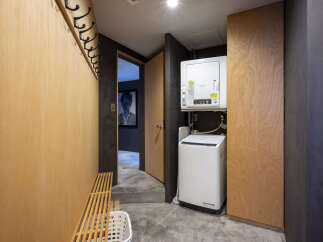 Discover modern living with this stylish laundry area, featuring a stacked washer and dryer for space efficiency.