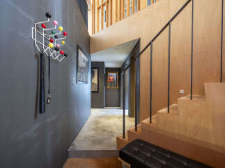 Discover modern living in this stylish entryway featuring a unique coat rack with colorful accents and a sleek black bench.