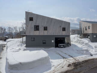 Discover modern living in this unique architectural home, featuring a striking asymmetrical wooden facade and a sleek grey lower level.