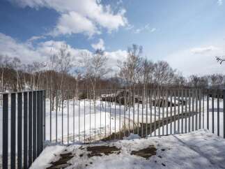 Experience the serene beauty of a winter wonderland with this property, nestled amidst a snow-covered landscape and surrounded by bare trees.