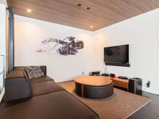 Experience modern living in this stylish entertainment room, featuring a plush sectional sofa perfect for movie nights.
