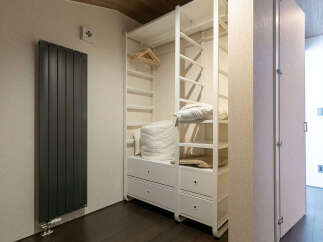 Discover modern living with this stylish open closet featuring ample shelving and drawers for organized storage.