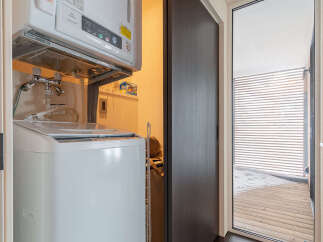 Discover the convenience of this compact laundry space, featuring a stacked washer and dryer unit for efficient use of room.