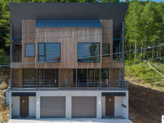 Discover modern living in this multi-level home featuring a striking wood-paneled facade and large windows that invite natural light.