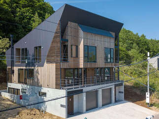 Discover modern living in this multi-story home, featuring a striking combination of wood and metal siding.