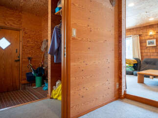 Step into a warm and inviting entryway featuring rich wood paneling throughout, creating a cozy and rustic ambiance.