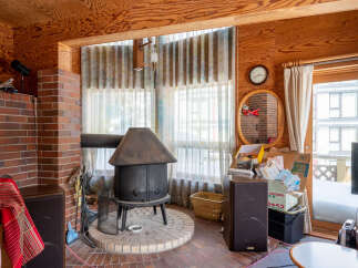 Cozy living room featuring a rustic brick fireplace with a wood-burning stove, perfect for warm gatherings.