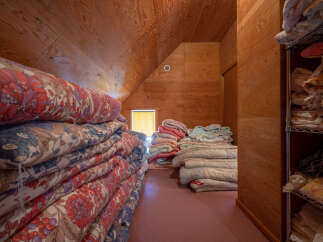 Discover ample storage solutions in this charming attic space, perfect for stowing away seasonal bedding and linens.