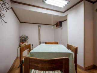 This cozy dining area features a charming wooden table set with a light green tablecloth, perfect for intimate meals.