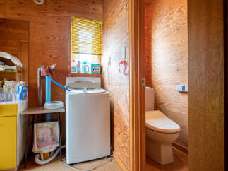 This charming bathroom features a functional washing machine and a separate toilet area, perfect for a compact living space.