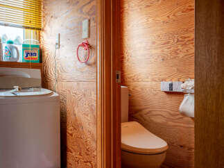 Discover a functional and stylish bathroom space featuring a modern washing machine and a well-appointed toilet area.
