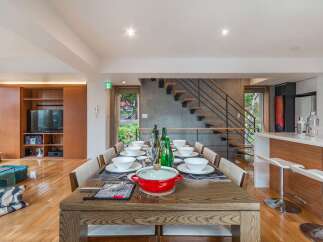Experience elegant dining in this spacious home, featuring a large wooden table set for a feast.