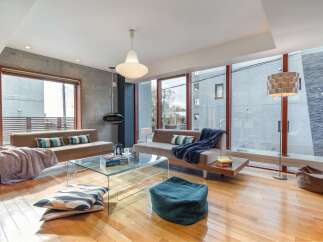 Experience modern living in this stunning open-concept living space, featuring a sleek glass coffee table and comfortable seating arrangements.
