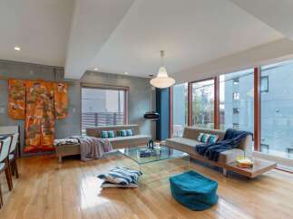 Experience modern living in this spacious apartment featuring a sleek concrete accent wall and expansive floor-to-ceiling windows that flood the space with natural light.