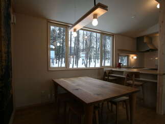 Experience cozy living in this charming dining area featuring a rustic wooden table perfect for family meals.