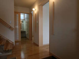 Step into this beautifully designed hallway featuring warm hardwood floors and a modern staircase.