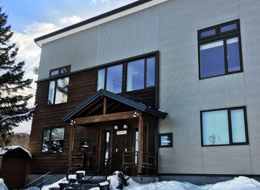 Experience modern living in this stunning multi-story home, featuring a striking contrast between warm wooden siding and sleek, light-colored exterior panels.