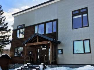 Experience modern living in this stunning multi-story home, featuring a striking contrast between warm wooden siding and sleek, light-colored exterior panels.