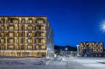 Experience modern living in this stunning multi-story building, featuring a unique facade with vertical wooden elements and abundant natural light through large windows.