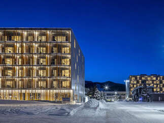 Experience modern living in this stunning multi-story building, featuring a unique facade with vertical wooden elements and abundant natural light through large windows.