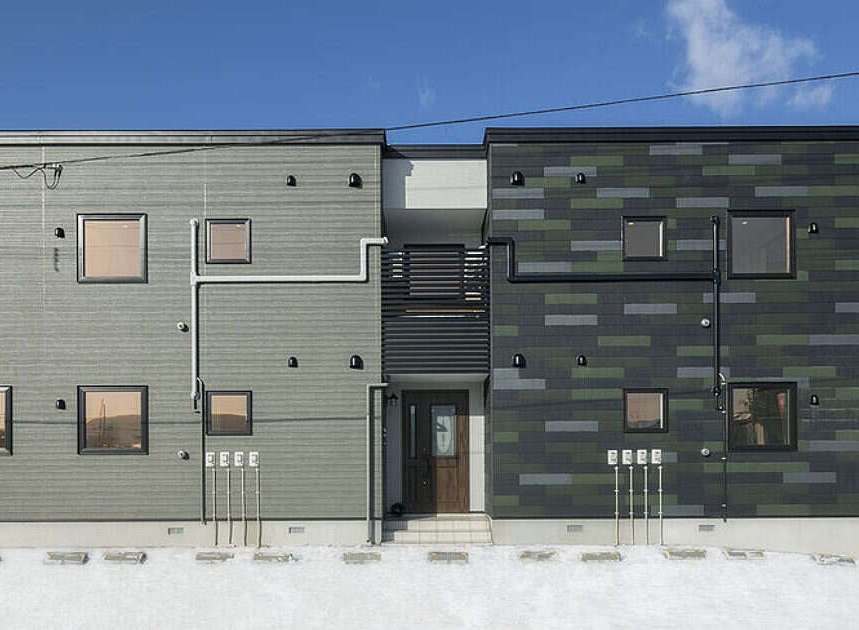 Discover modern living at Norfino Design Apartment, featuring a striking exterior with a unique blend of grey and green tiled facades.