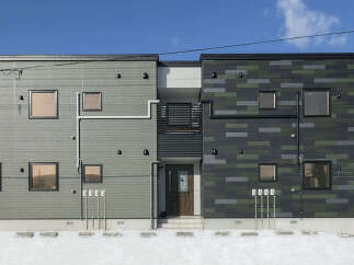 Discover modern living at Norfino Design Apartment, featuring a striking exterior with a unique blend of grey and green tiled facades.