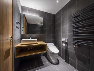 Experience modern luxury in this sleek bathroom featuring a floating wood vanity with a vessel sink and a high-tech toilet.