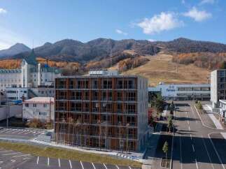 Discover modern living in this contemporary building, featuring a striking facade with warm wood accents and numerous windows for abundant natural light.