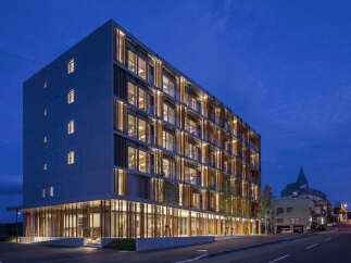 Experience modern living in this stunning multi-story building, featuring a unique facade with vertical wooden louvers and expansive windows that offer abundant natural light.